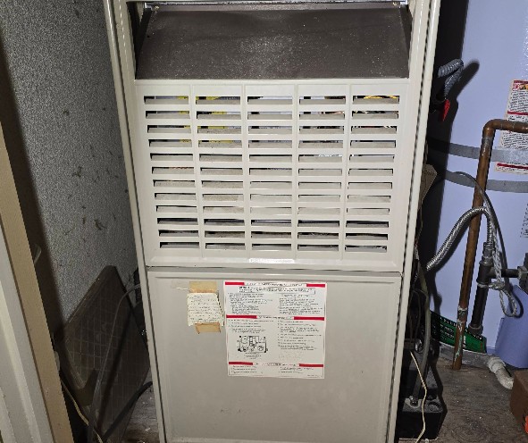 Technician repairing a faulty sensor in a furnace system